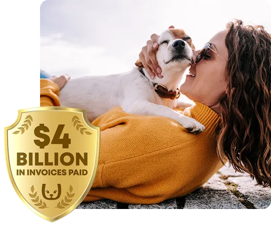 Woman laying on a seawall with her pet dog sitting on her