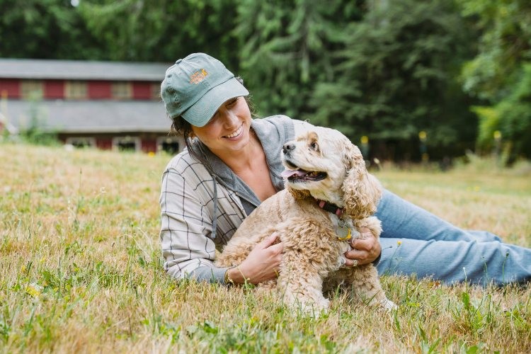 Woman relaxing in grass with her dog