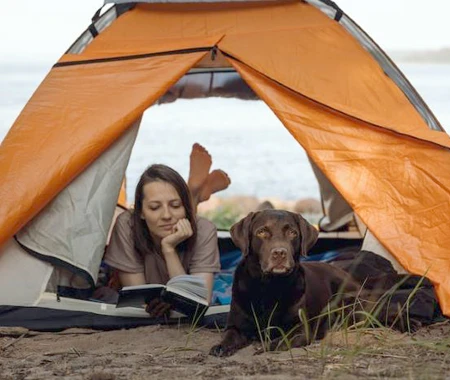 A woman with her dog in a tent